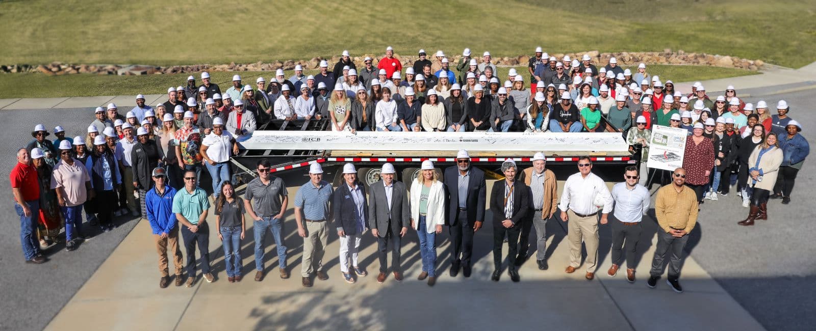 Faculty, staff, and community members gather around a signed steel beam during the December 2025 beam signing ceremony for the new robotics building.